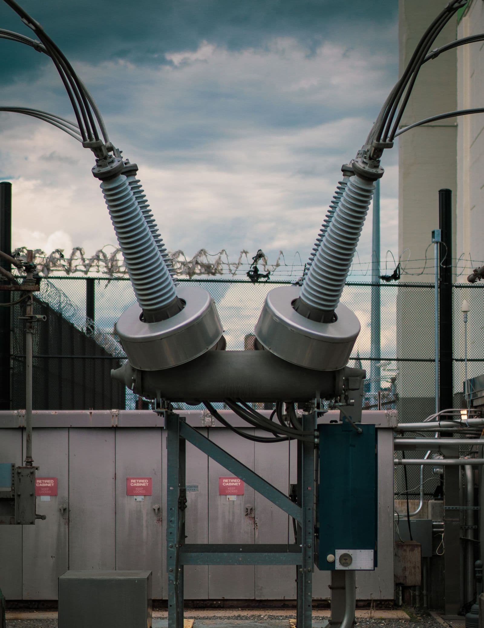 Two bushings rising from a substation circuit breaker