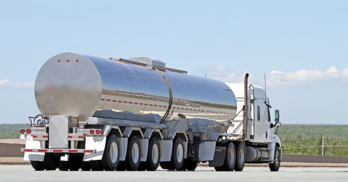 Stainless steel tanker trailer pulled by a semi truck on an open road